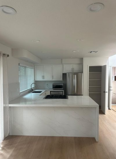 Contemporary kitchen with white cabinets and stainless steel appliances.