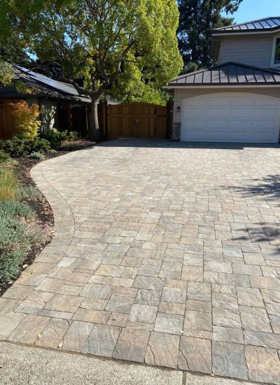 Beautiful paved driveway with landscaping and a garage in a residential home.